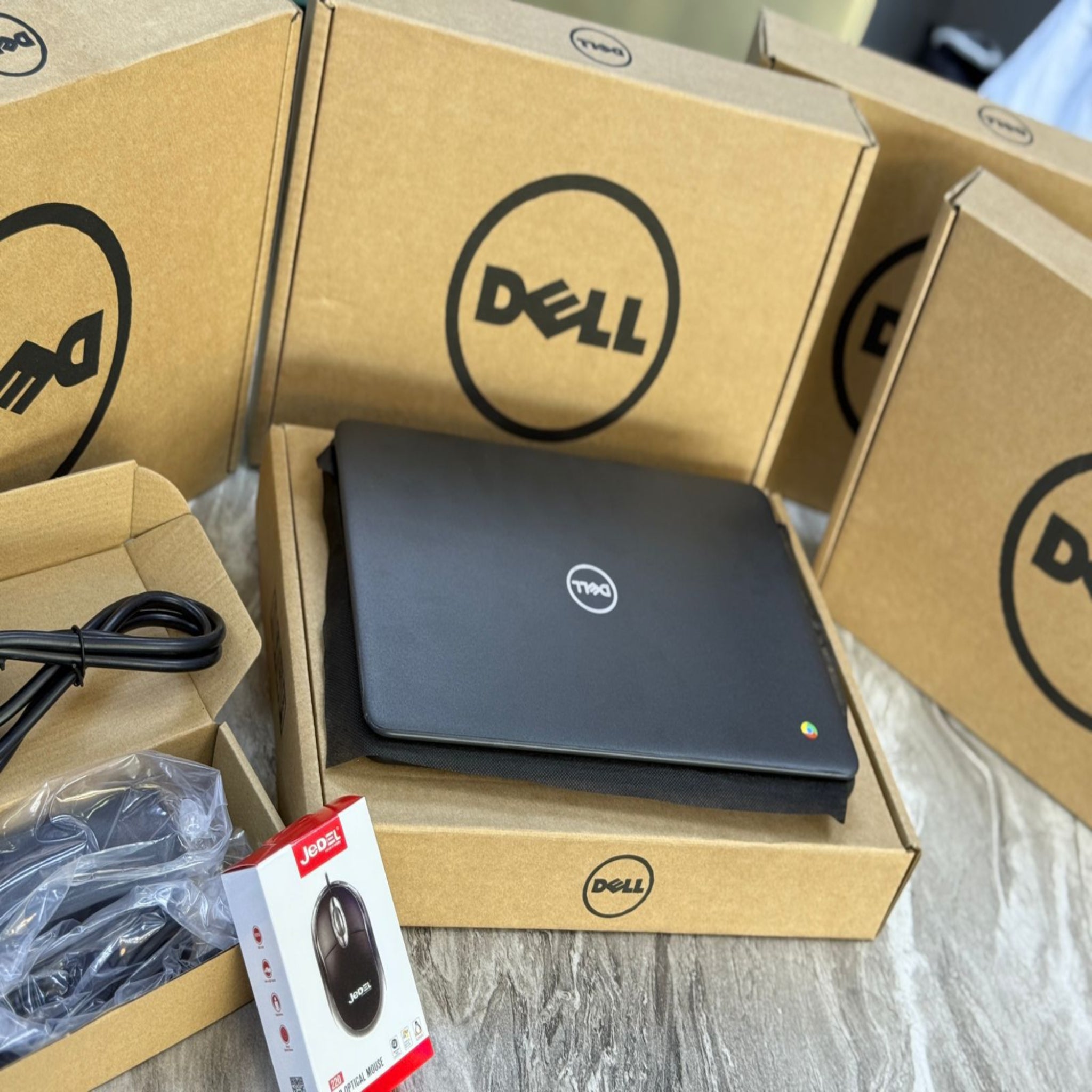 Dell laptop in an open box with accessories on a light surface